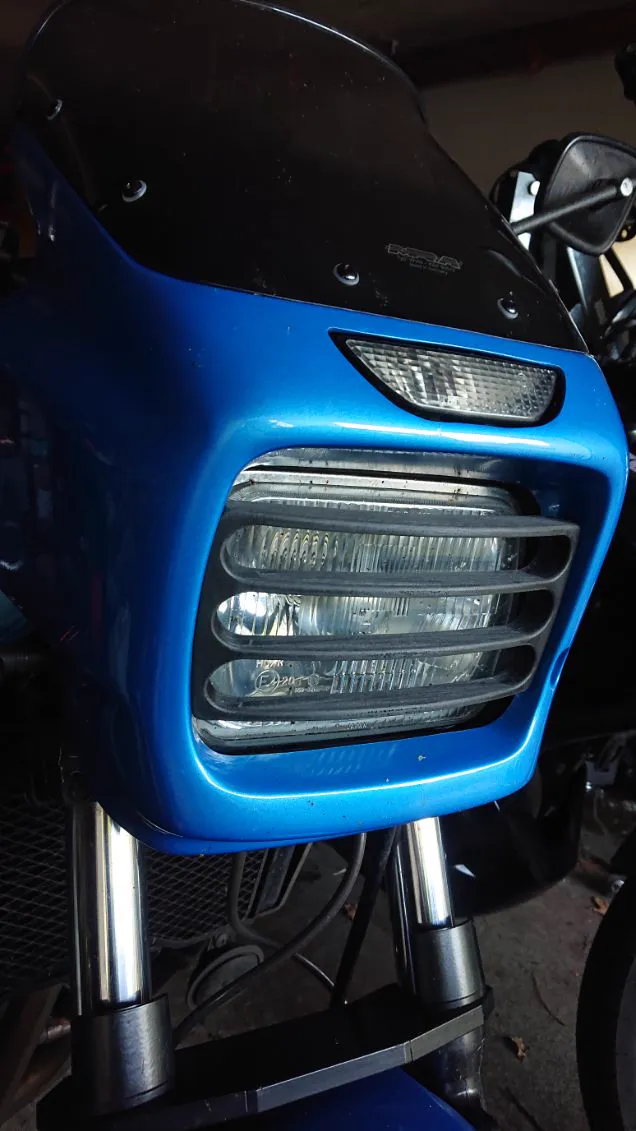 Grille de phare imprimée et peinte en bleu, montée sur une moto